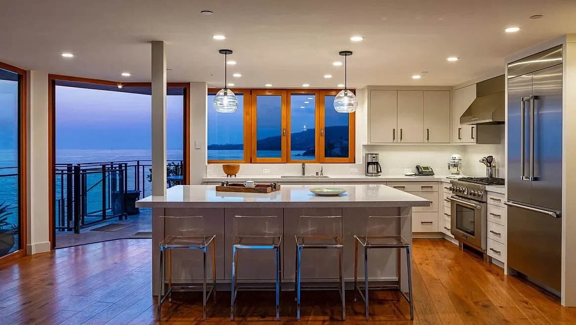 A kitchen with a large island and white cabinets.